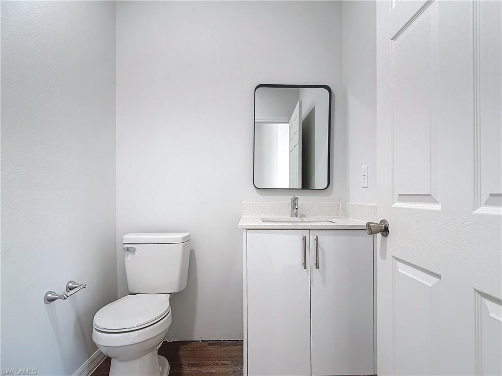 Half bath featuring vanity and dark wood-style flooring
