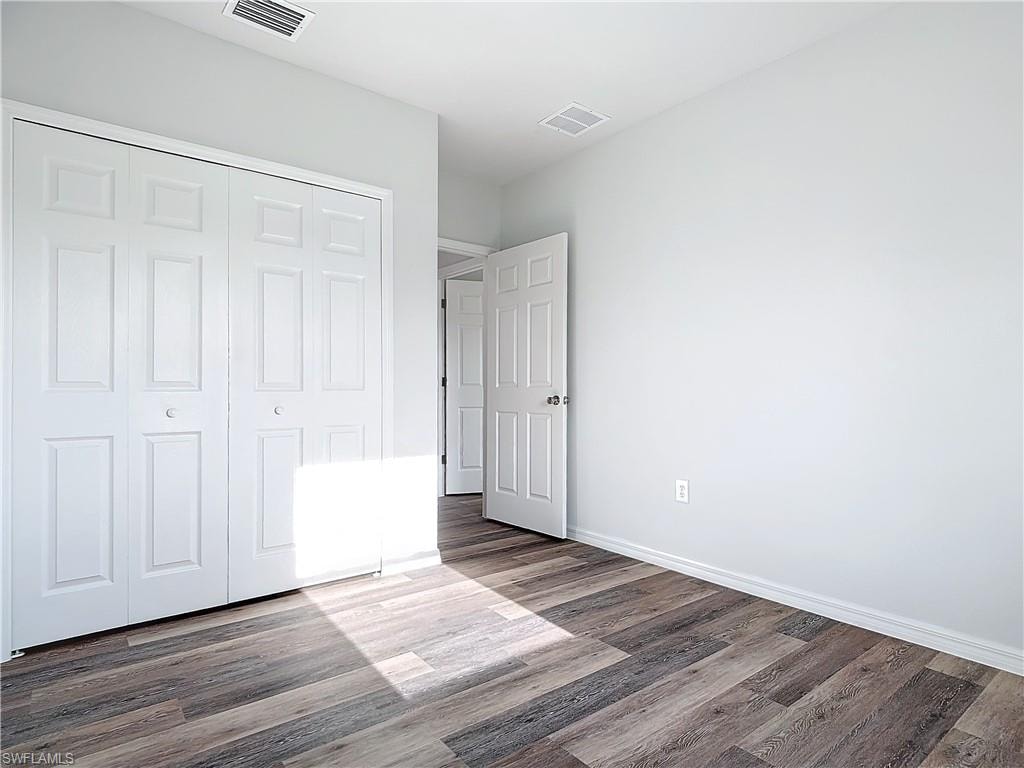 Unfurnished bedroom featuring wood finished floors and a closet