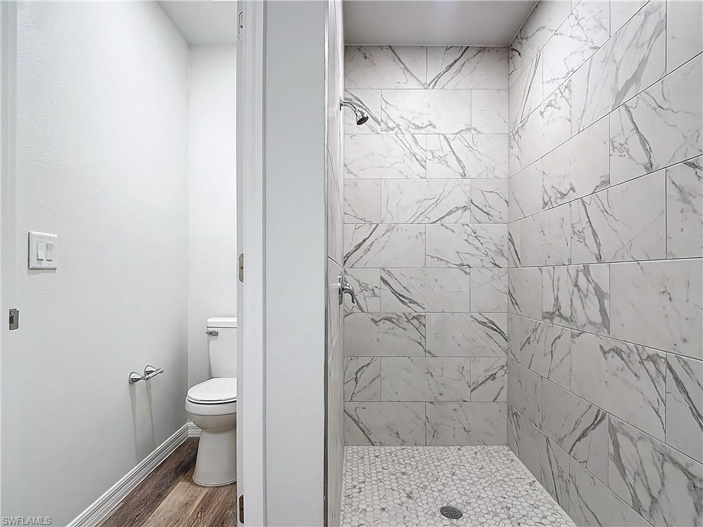 Bathroom with a shower stall and wood finished floors