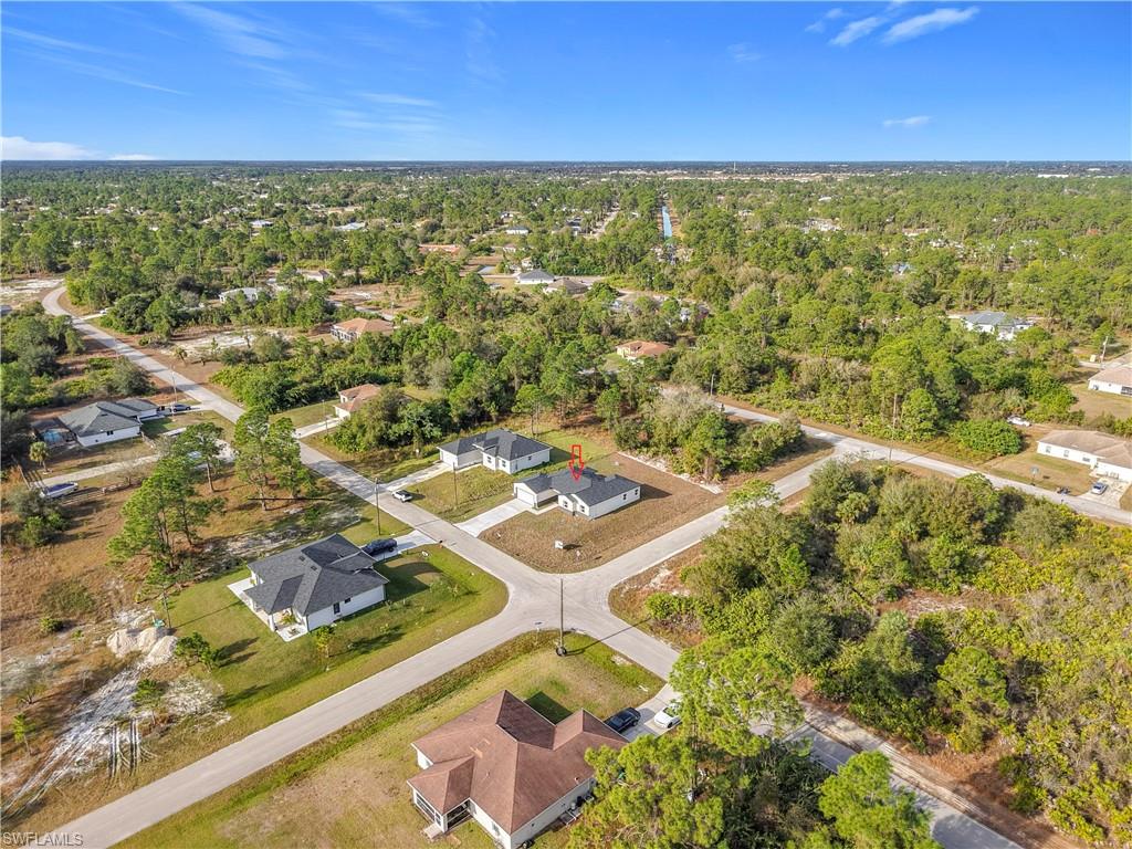 Aerial view of property and surrounding area with nearby suburban area