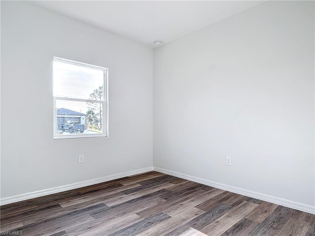 Empty room with baseboards and wood finished floors