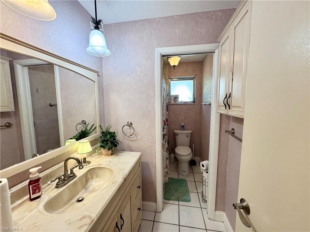 Vanity with an integrated sink, antiqued brass-tone faucet, and a large wall mirror