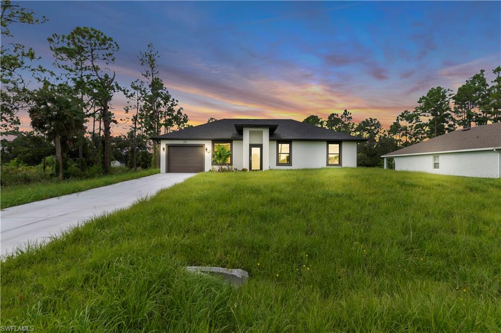 Contemporary single-story residence with a dark roof and white stucco exterior