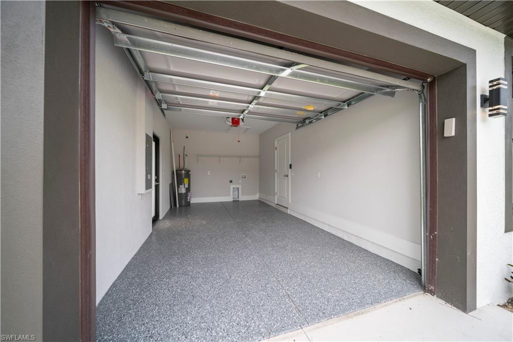 Attached garage with a speckled epoxy floor, white walls, and built-in shelving