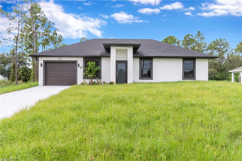 Contemporary single-story residence featuring a dark shingle roof, white stucco exterior, and dark-framed windows