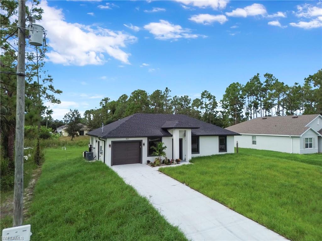 Contemporary exterior with a dark-pitched roof, white stucco facade, and an attached garage