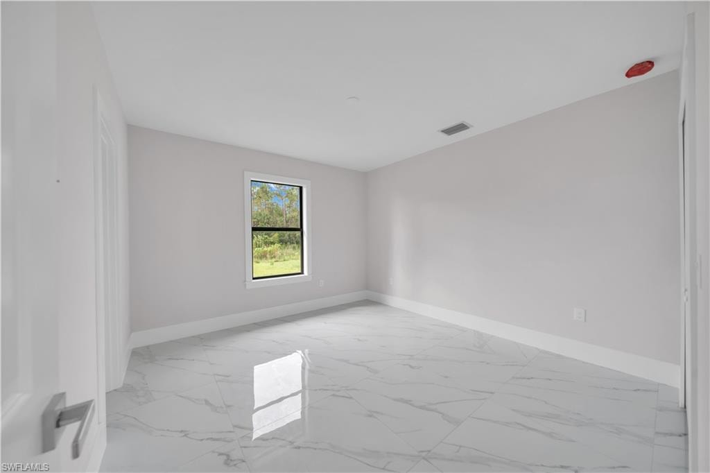 High ceilings, neutral paint, single window, white trim, and a tile floor
