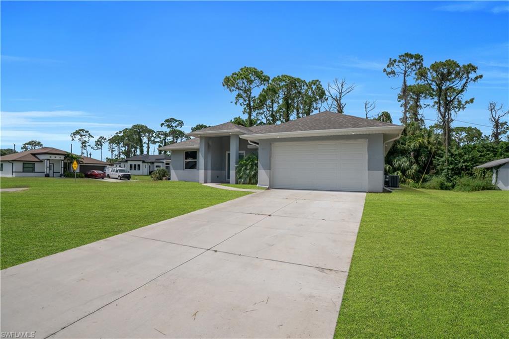 Contemporary single-story residence with an attached garage, concrete driveway, and a shingle roof