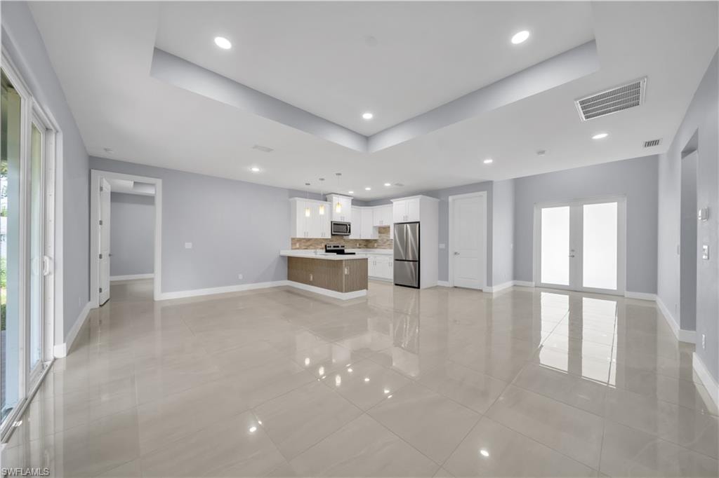 Open-concept living space with large format tile flooring and recessed lighting