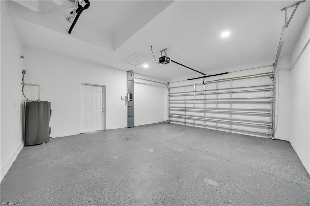 Spacious garage featuring a durable concrete floor, recessed lighting, and an automatic garage door opener