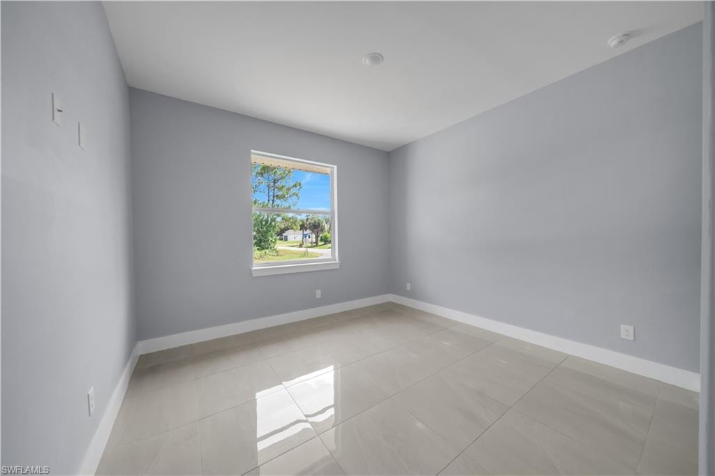 Neutral-toned ceramic tile flooring, a large window, and recessed lighting