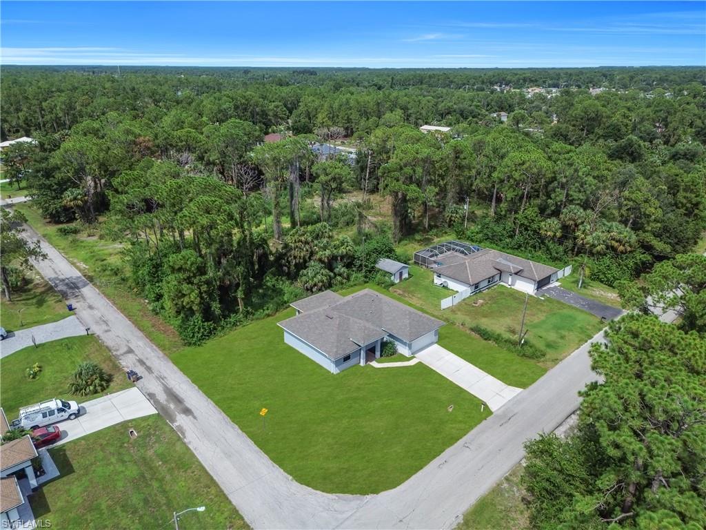 Property with a manicured lawn, paved driveway, and perimeter fencing