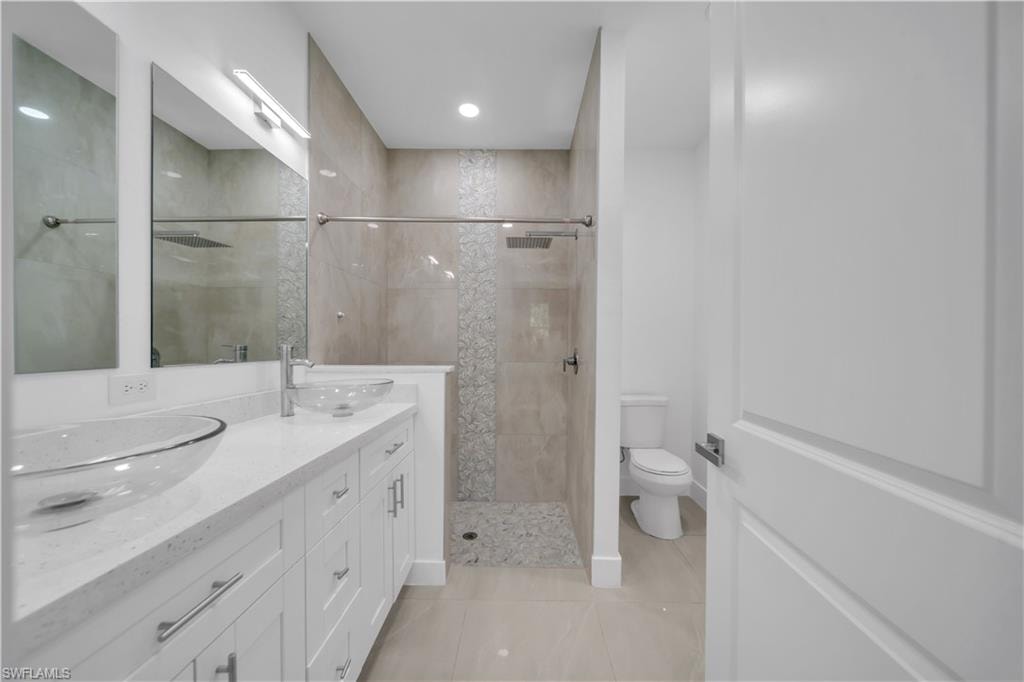 Dual glass vessel sinks set on a white vanity with brushed nickel hardware and a light-toned countertop