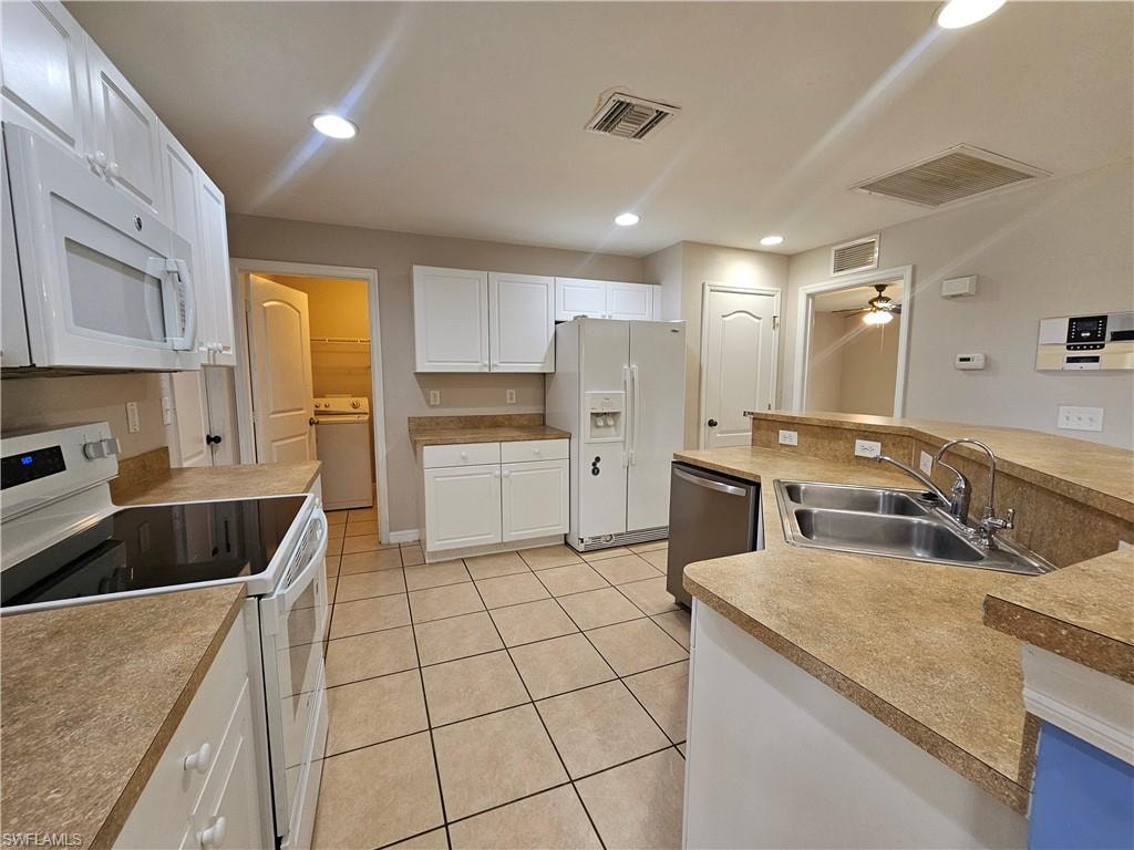 Kitchen featuring white cabinetry, tile flooring, and integrated stainless steel appliances