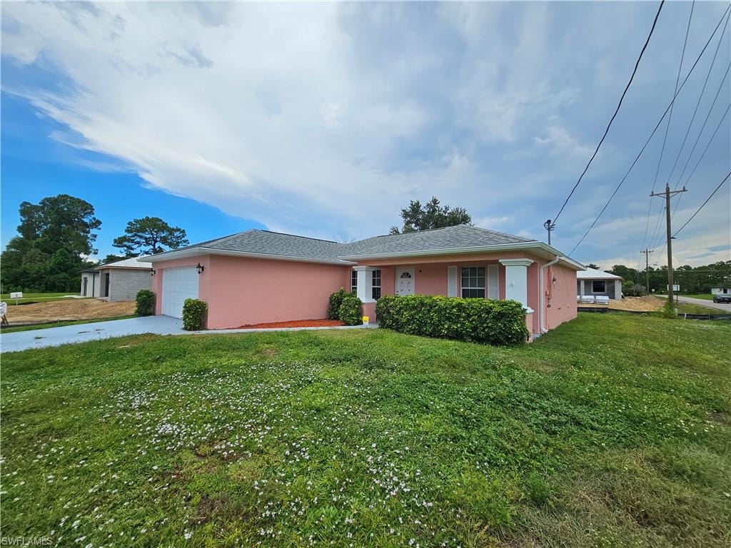 Single-story residence with a stucco exterior, attached garage, covered entryway, and a paved driveway