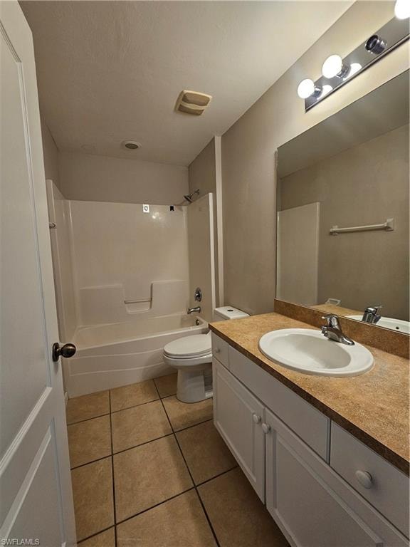 Dual vanity bathroom featuring ceramic tile flooring, wood-finish countertops with round undermount sinks, chrome fixtures, and recessed lighting