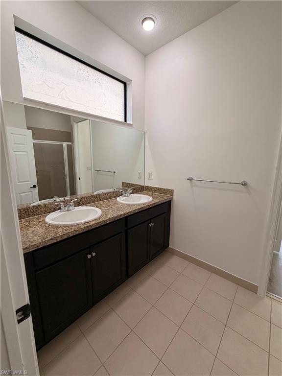 Dual vanity with granite countertops, integrated sinks, dark wood-finish cabinetry, and an expansive wall mirror