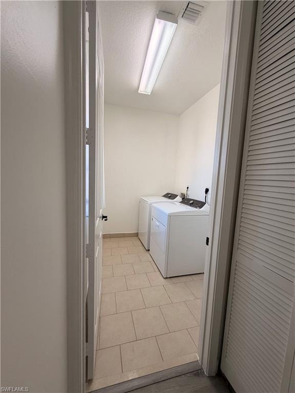 Laundry area with tile flooring, white walls, and a fluorescent ceiling light