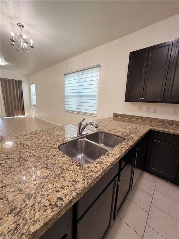 Kitchen island featuring a double basin stainless steel sink, a chrome faucet, and brown cabinetry