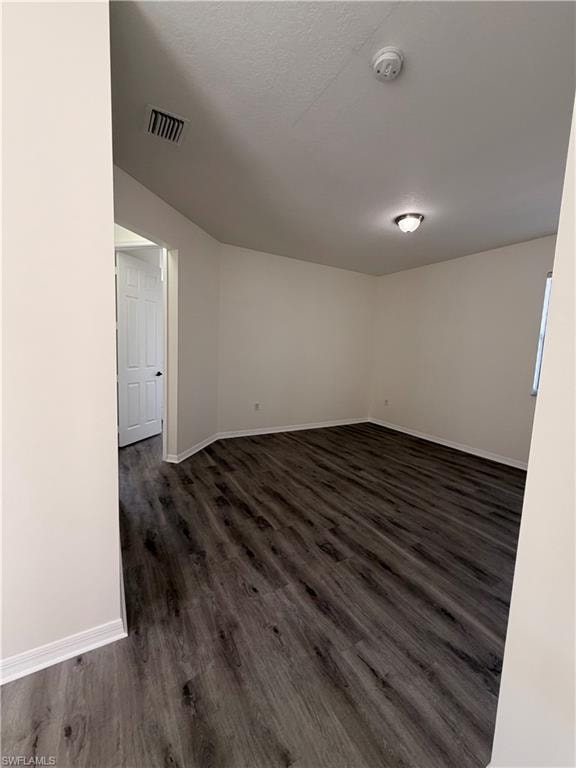Dark wood-finish flooring, light neutral wall tones, and overhead lighting