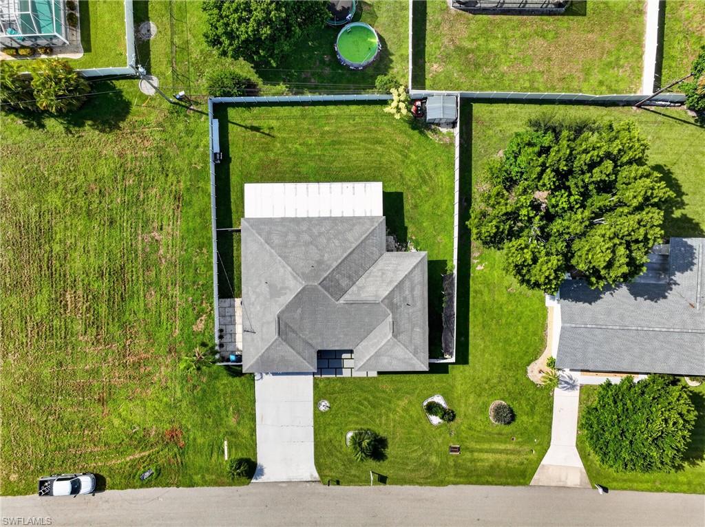 Pitched roofline, concrete driveway, fenced yard, and a paved walkway