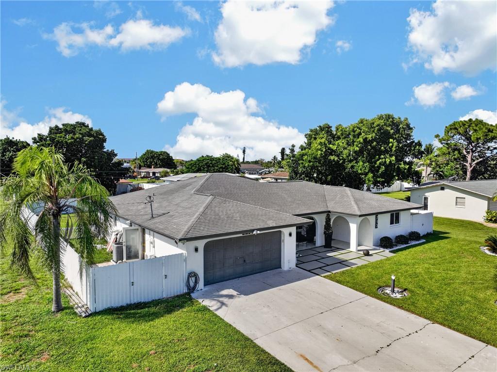 Single-story residence featuring a gray shingle roof, white exterior, arched entry, and an integrated two-car garage