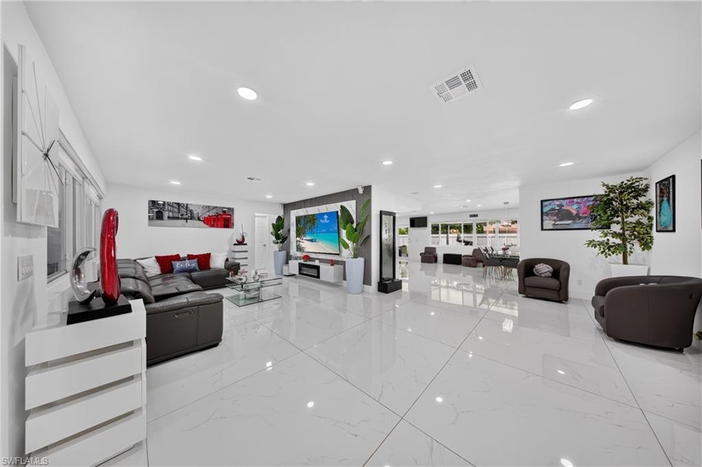 Spacious interior with large format white tile flooring, recessed lighting, and expansive windows