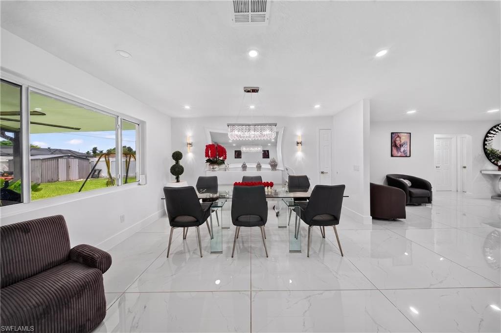 Spacious dining area featuring large windows, recessed ceiling lighting, and reflective tile flooring