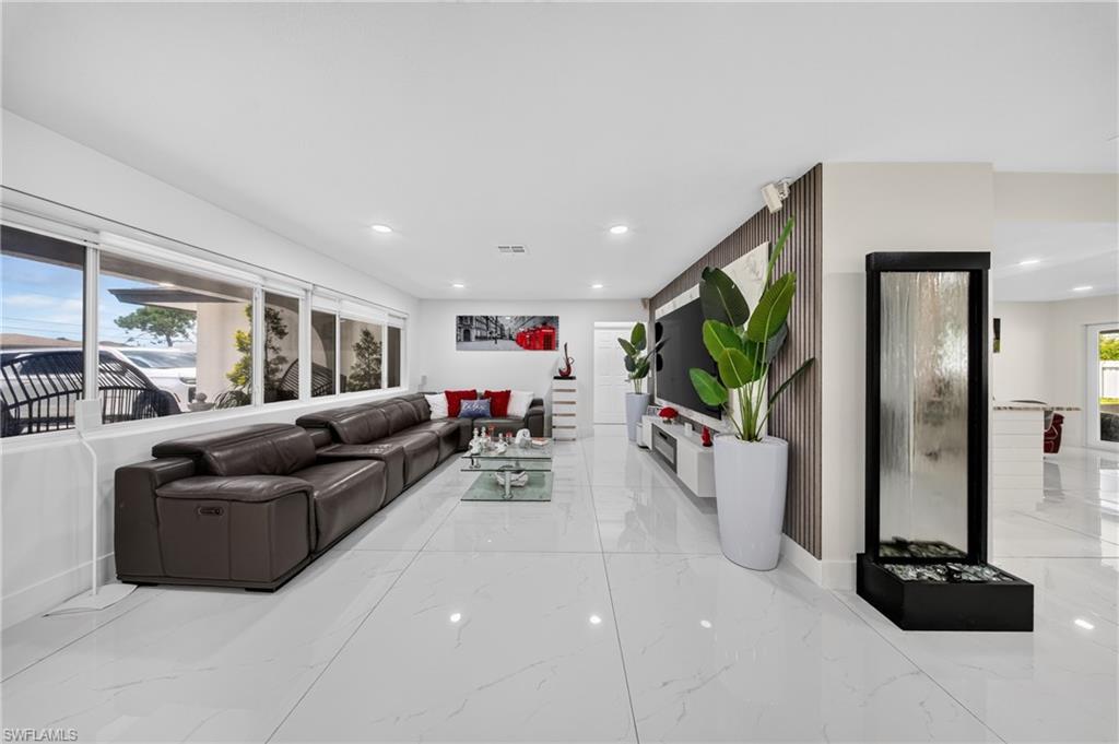 White tile flooring, recessed lighting, and a contemporary wall feature with vertical wood paneling