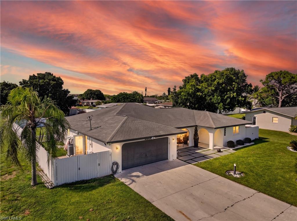 Single-story residence featuring a gray shingle roof, attached garage, and concrete driveway