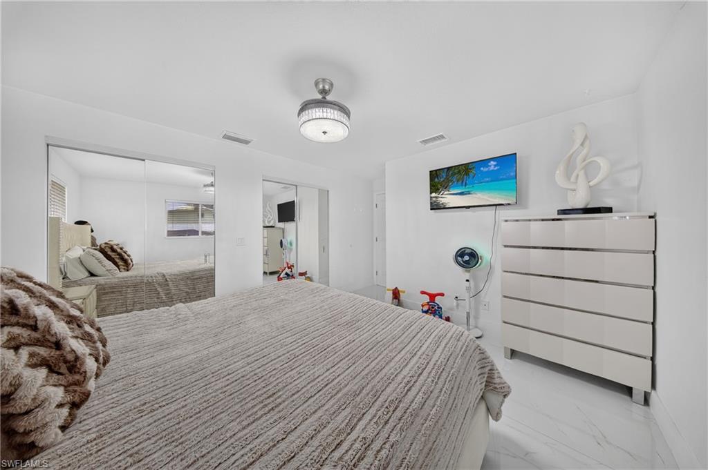 White tile flooring, overhead drum light fixture, and mirrored closet doors