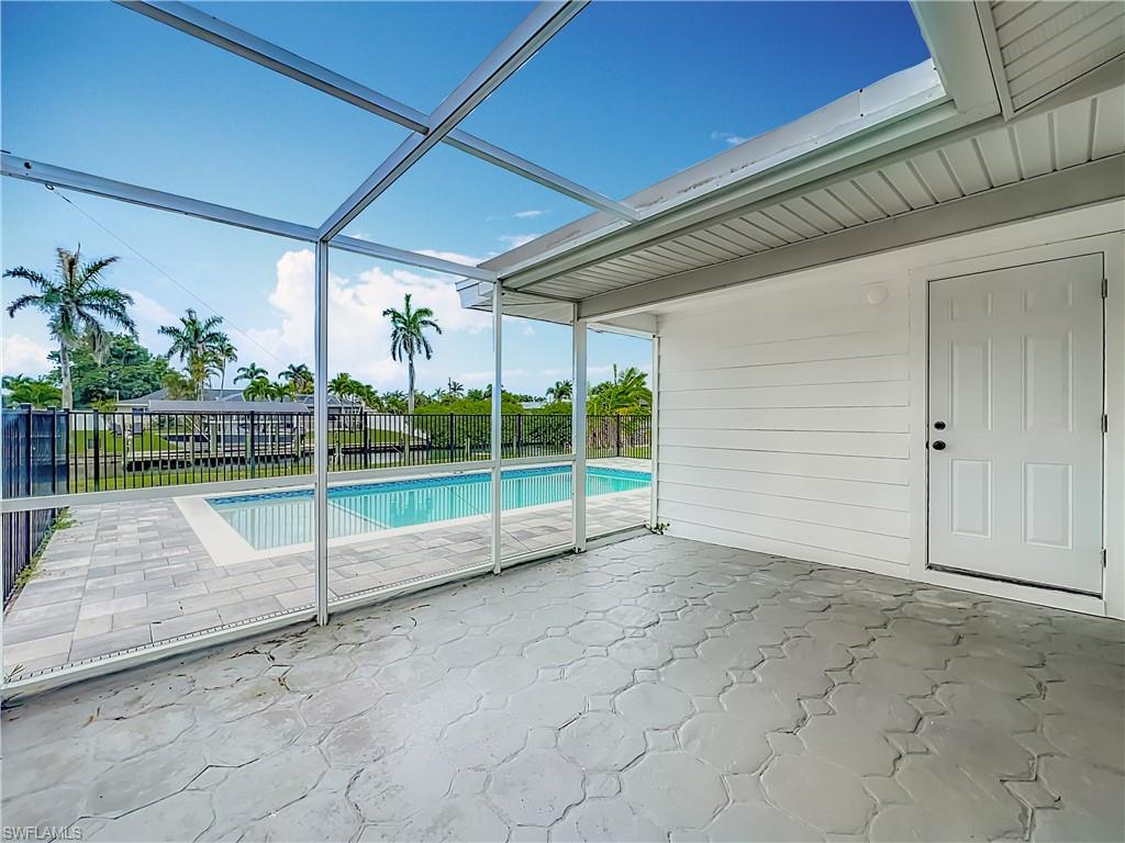 Screened-in patio with patterned concrete flooring, a private swimming pool, and a paved pool deck