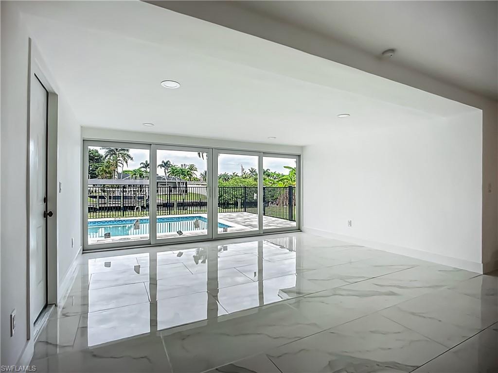 Recessed lighting, large format tile flooring, sliding glass doors, private swimming pool, and a fenced backyard