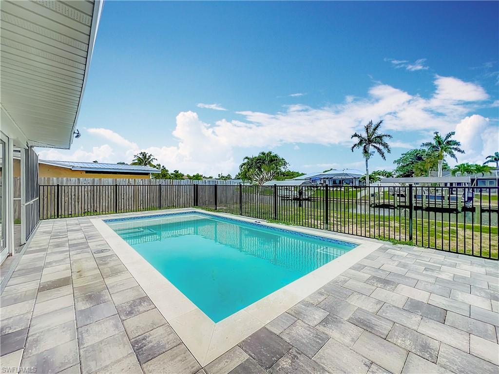 In-ground swimming pool with a tiled border and paver patio