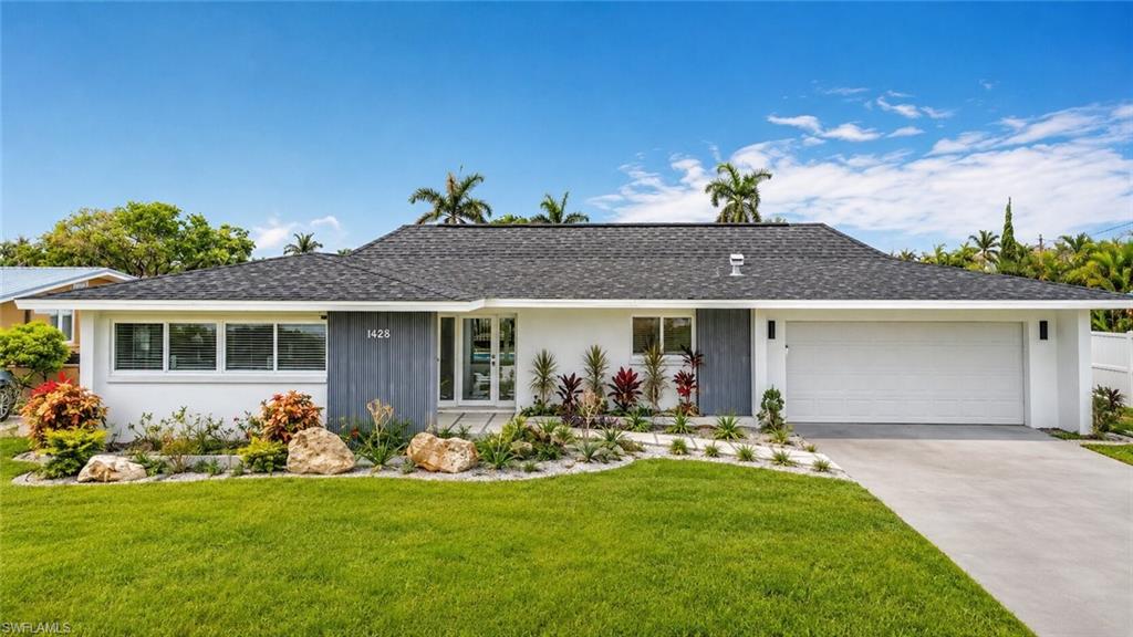 Crisp white exterior with contrasting gray siding, a dark shingle roof, a two-car garage, and a concrete driveway