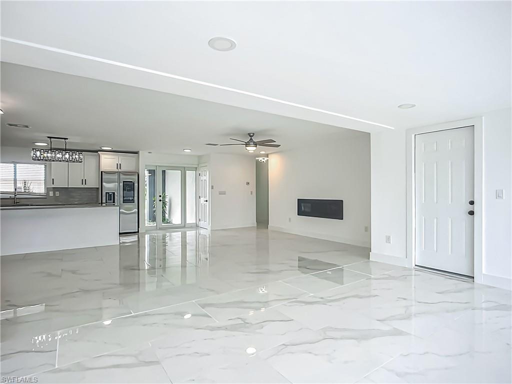 Polished tile flooring, recessed lighting, and a built-in electric fireplace