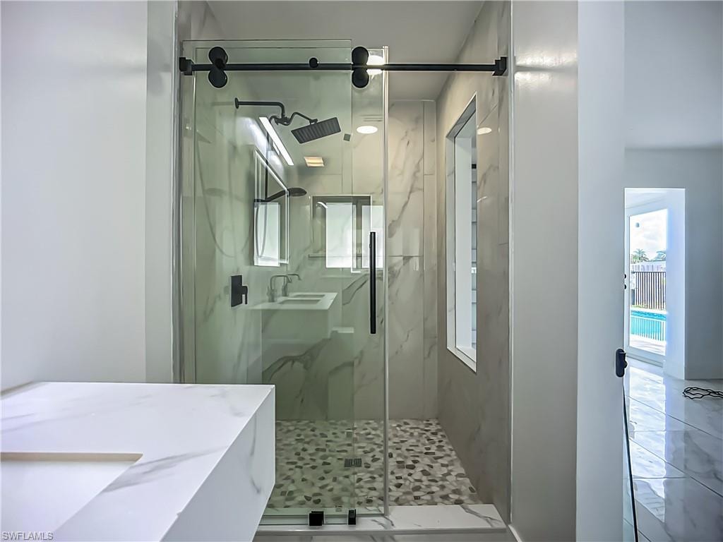 Walk-in shower with clear glass enclosure and black hardware