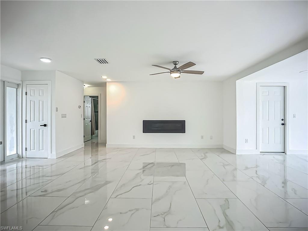White tile flooring with veining, recessed lighting, ceiling fan with integrated light, and white paneled doors
