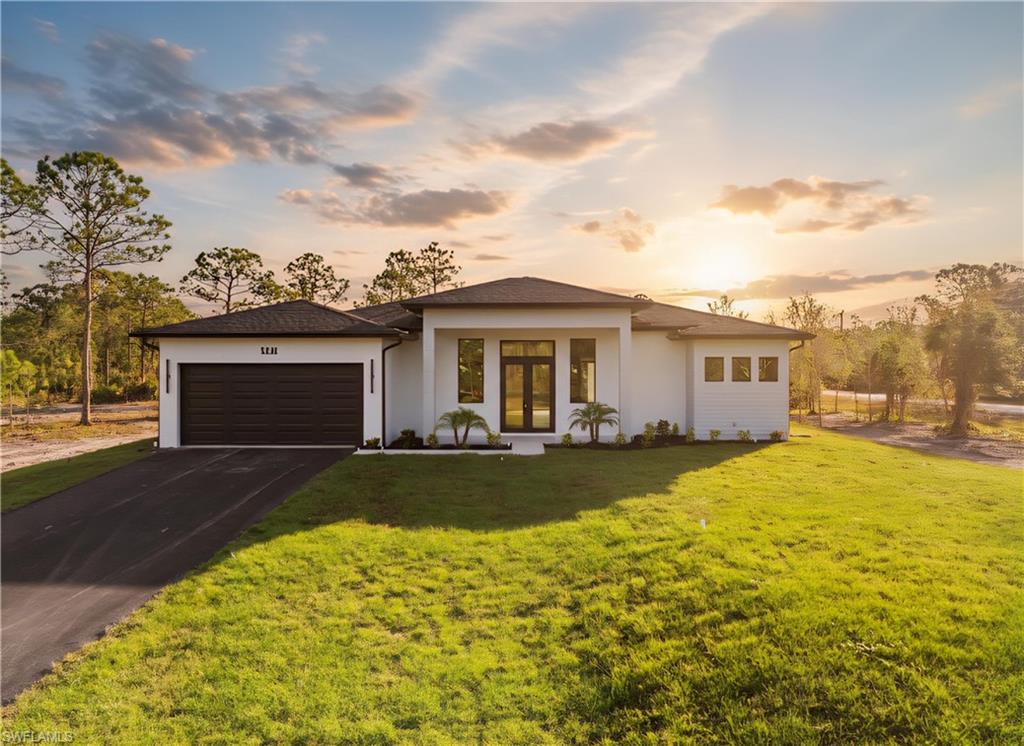 Contemporary single-story residence featuring a dark asphalt shingle roof, white stucco exterior, and black framed windows