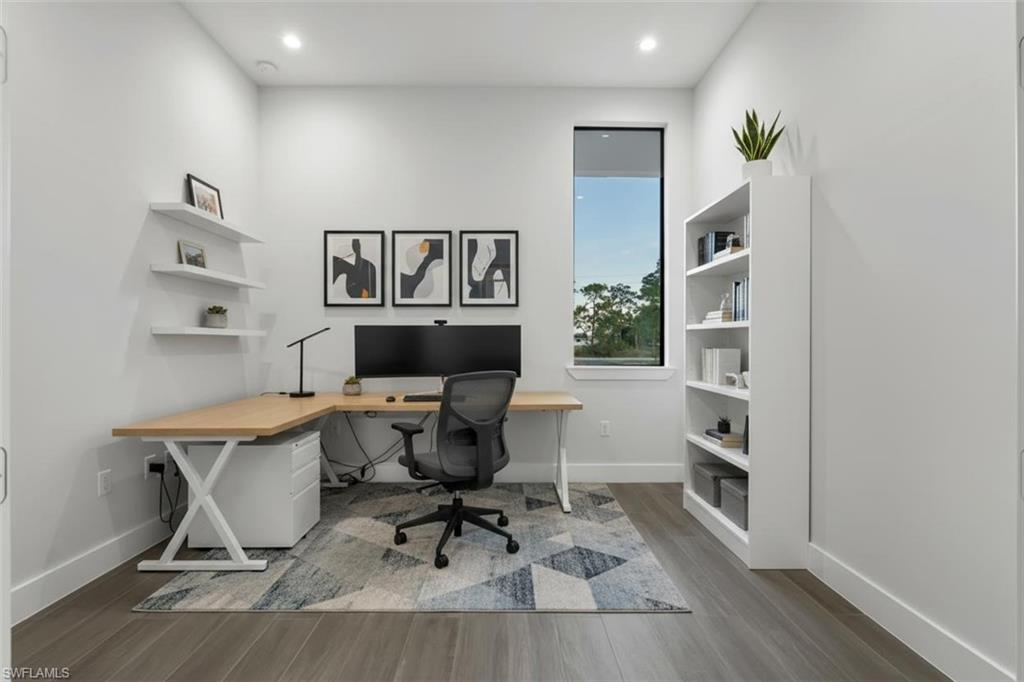 Built-in shelving, recessed lighting, wood-finish flooring, and a large window