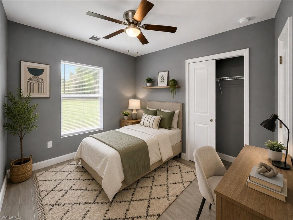 Ceiling fan with integrated lighting, wood-finish flooring, single window with blinds, built-in shelving, and sliding closet doors