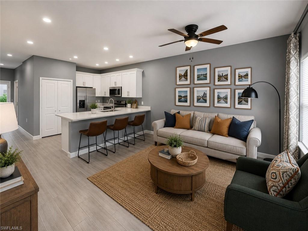 Open-concept living area featuring wood-finish flooring, recessed lighting, and a ceiling fan