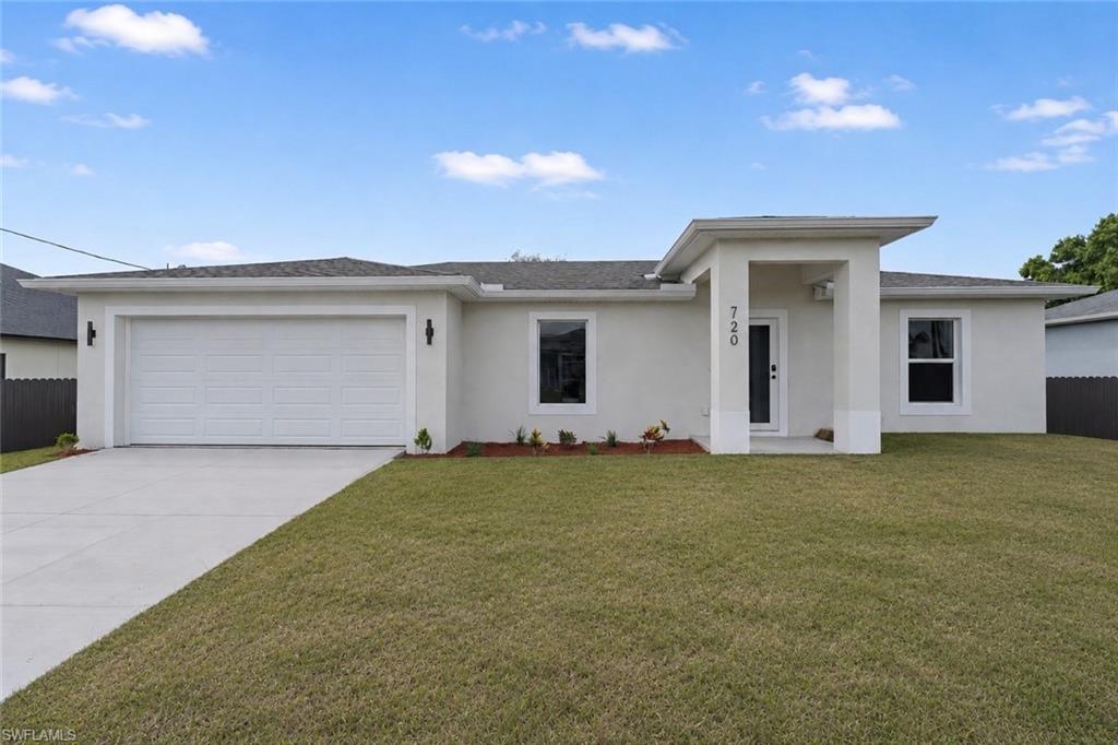 Contemporary stucco exterior with a covered entry, attached two-car garage, and a concrete driveway