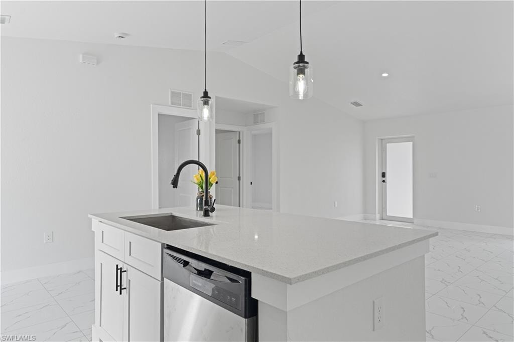 Kitchen island featuring a stainless steel sink, black faucet, and white countertop