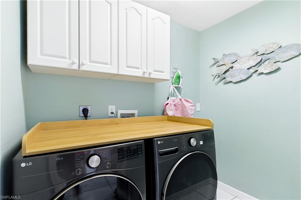 Large laundry room with white cabinets.