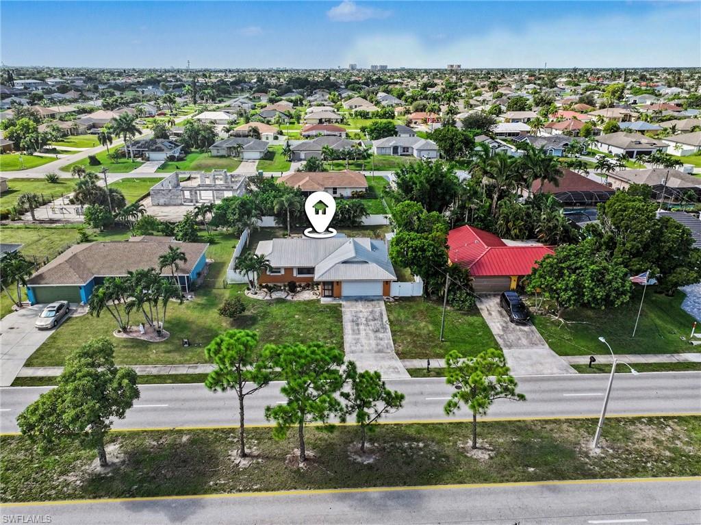 Single-story residence with an attached garage, paved driveway, and mature landscaping