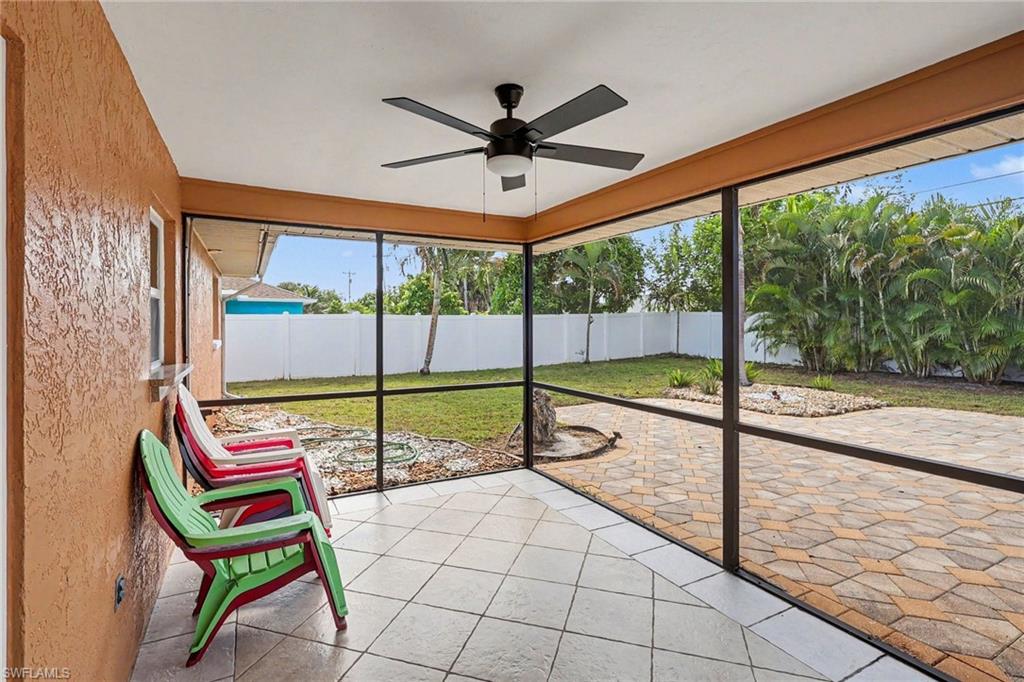 Screened patio featuring a ceiling fan, tiled flooring, and a paver patio area