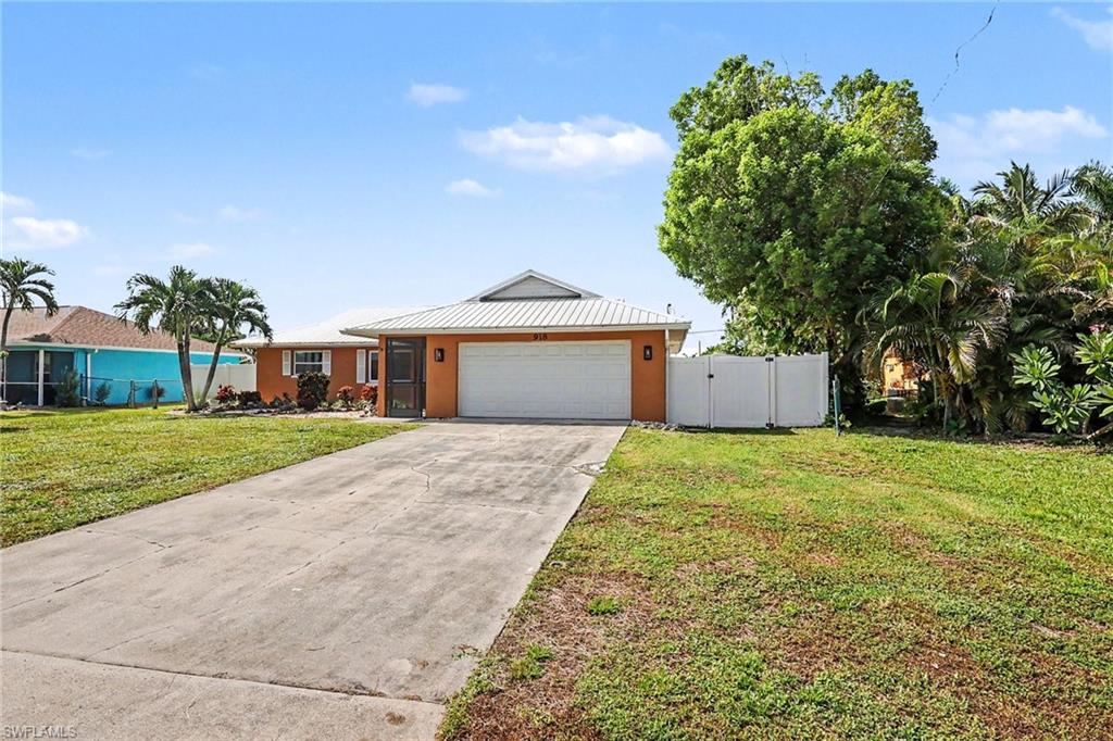 Orange exterior with a white garage door, metal roof, and concrete driveway