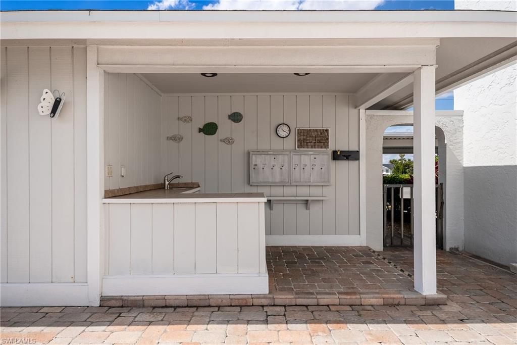 Covered outdoor area featuring a built-in countertop with a sink, recessed lighting, and brick paver flooring