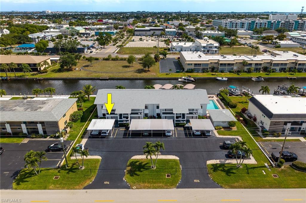 Canal-front property featuring a swimming pool, covered parking, and direct water access with multiple boat slips